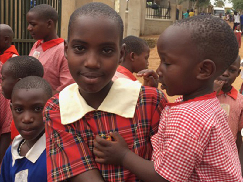 Student at Makasa School, in Uganda, holding a fellow student